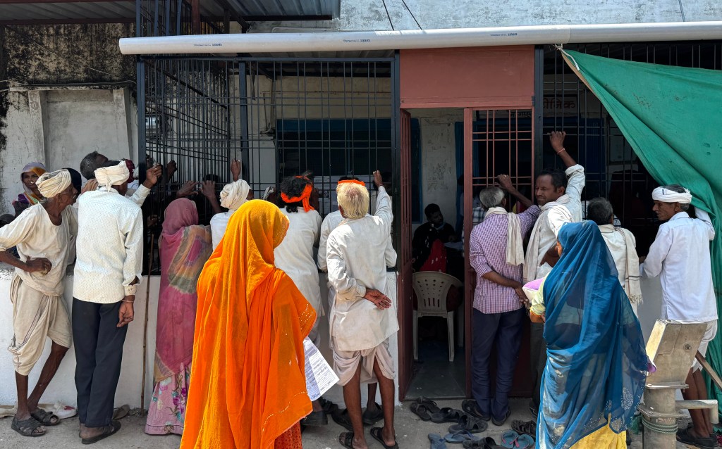 People standing and waiting outside a clinic entrance